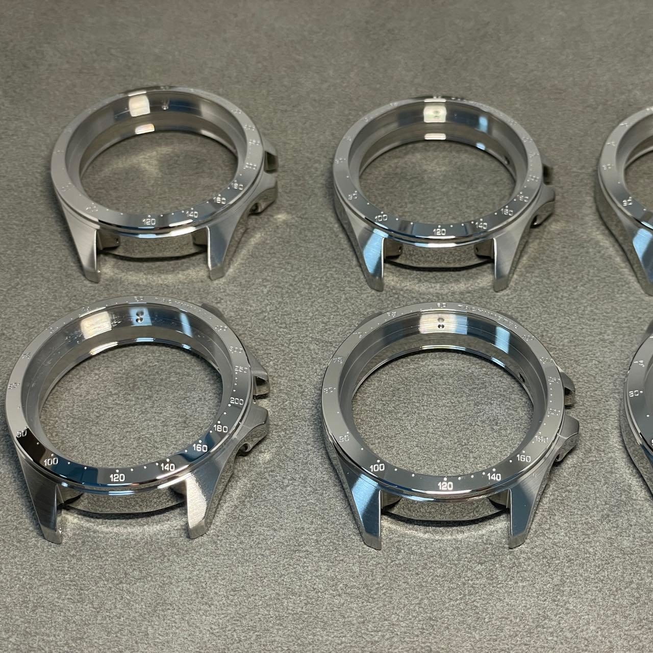 A luxury watch case being engraved with precise text using an etching machine.