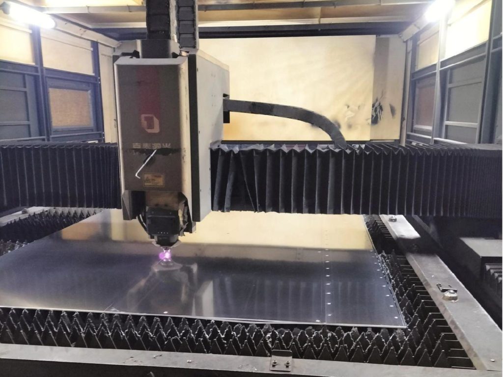 Sheet metal being laser cut into intricate shapes for industrial applications.